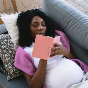 pregnant woman writing in journal